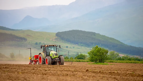 Traktor pluhy pole na jaře. — Stock fotografie