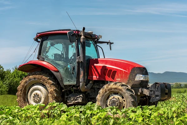 Panen tanaman dengan traktor merah di pegunungan hijau alpen austrian — Stok Foto