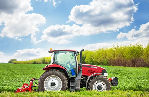 Traktor merah memotong rumput . — Stok Foto