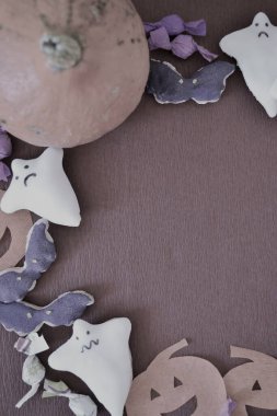 Yarasa ve hayalet şekilli kurabiyelerle Cadılar Bayramı kompozisyonu, gerçek ve kağıt balkabakları ve şekerler