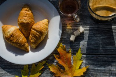 Bir fincan kahve, dökülen yapraklar ve şekerlerle dolu bir hayat