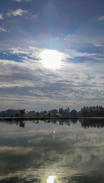 Sunny day on the perfect lake. Autumn lake with reflection on the water. Cloudy sky in the sunny day.