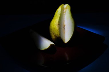 Sonbahar armudu sade bir hayat. Kusursuz armut silueti, düşük ışık ve derin gölge..