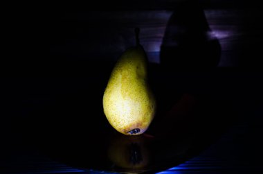 Sonbahar armudu sade bir hayat. Kusursuz armut silueti, düşük ışık ve derin gölge..