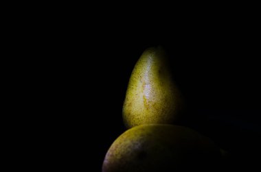 Sonbahar armudu sade bir hayat. Kusursuz armut silueti, düşük ışık ve derin gölge..