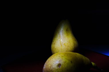 Sonbahar armudu sade bir hayat. Kusursuz armut silueti, düşük ışık ve derin gölge..