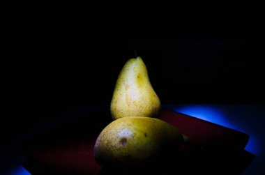 Sonbahar armudu sade bir hayat. Kusursuz armut silueti, düşük ışık ve derin gölge..