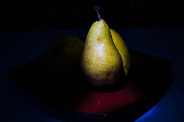 Sonbahar armudu sade bir hayat. Kusursuz armut silueti, düşük ışık ve derin gölge..