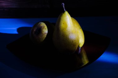 Sonbahar armudu sade bir hayat. Kusursuz armut silueti, düşük ışık ve derin gölge..