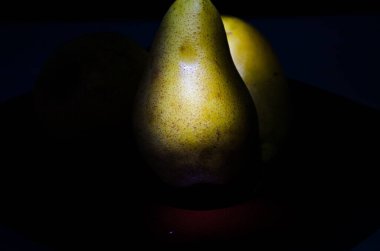 Sonbahar armudu sade bir hayat. Kusursuz armut silueti, düşük ışık ve derin gölge..