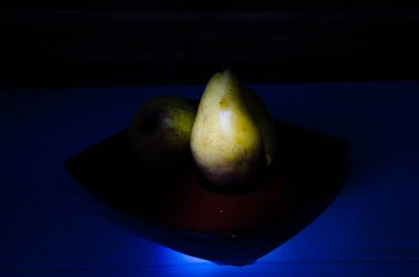 Sonbahar armudu sade bir hayat. Kusursuz armut silueti, düşük ışık ve derin gölge..