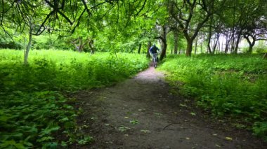 Bahar parkında bisiklet süren amatör bir binici.