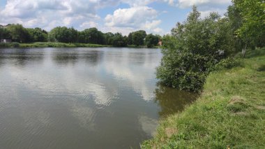 Bir göl manzarası ve yaz mevsiminde gökyüzünde bulutlar