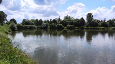 Bir göl manzarası ve yaz mevsiminde gökyüzünde bulutlar