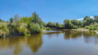 Bir göl manzarası ve yaz mevsiminde gökyüzünde bulutlar