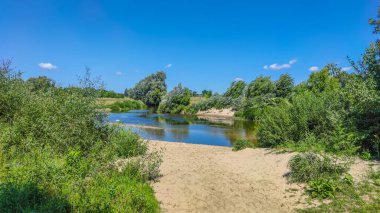Bir göl manzarası ve yaz mevsiminde gökyüzünde bulutlar