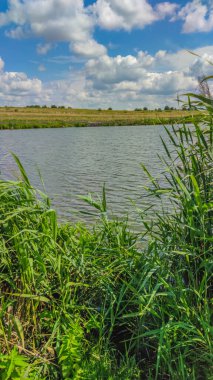 Bir göl manzarası ve yaz mevsiminde gökyüzünde bulutlar