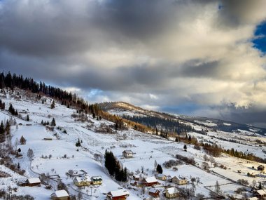 Karlı, gizemli Karpatlar bulutlu gökyüzünün altında güneşli bir havada