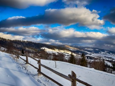Karlı, gizemli Karpatlar bulutlu gökyüzünün altında güneşli bir havada