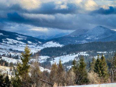 Karlı, gizemli Karpatlar bulutlu gökyüzünün altında güneşli bir havada