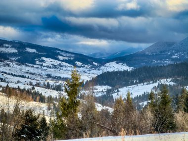 Karlı, gizemli Karpatlar bulutlu gökyüzünün altında güneşli bir havada