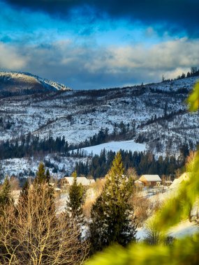 Karlı, gizemli Karpatlar bulutlu gökyüzünün altında güneşli bir havada