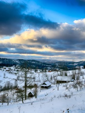 Karlı, gizemli Karpatlar bulutlu gökyüzünün altında güneşli bir havada