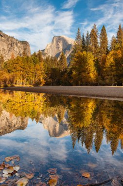 Yosemite 'de yarım bir kubbe manzarası ve nehirde mükemmel bir yansıma.