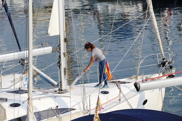 Barcelona, Spanien - den 25 September, 2014: Kvinnan tvättar yacht förtöjd på stranden i Barcelona Royaltyfria Stockbilder