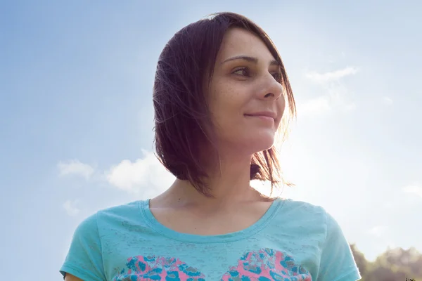 Portrait of a woman against the sky with sun rays — Stock Photo, Image