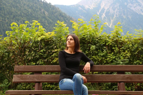 Girl on the bench on the background of mountains