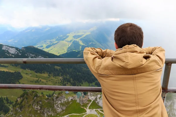 Dağda otururken görünümü delikanlı bakar