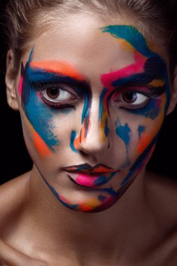 Koyu siyah arka plan üzerinde olağandışı makyaj ile genç bir kadın portresi kapatın