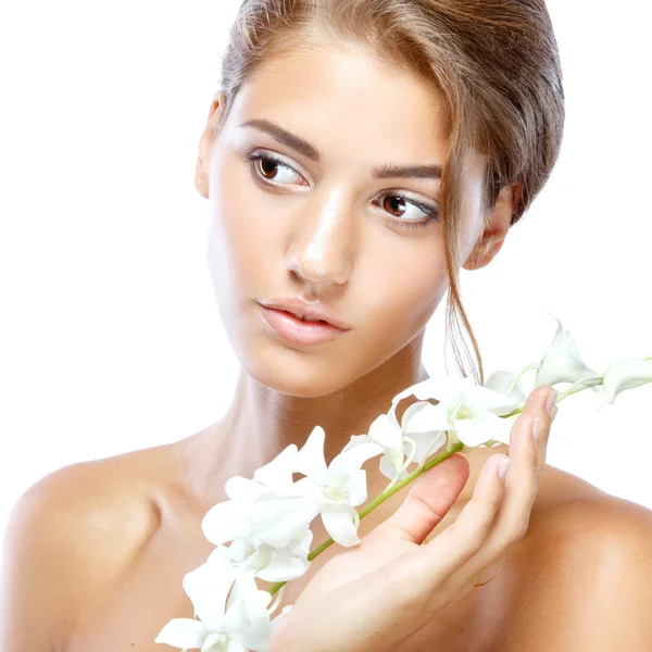 Açık yüz doğal olan kadın makyaj onun saçları hafif bir arka plan üzerinde beyaz çiçekli — Stok fotoğraf