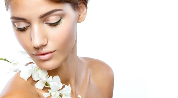 Young woman with clear face natural make up her hair up with a white flower on a light background — Stock Photo, Image