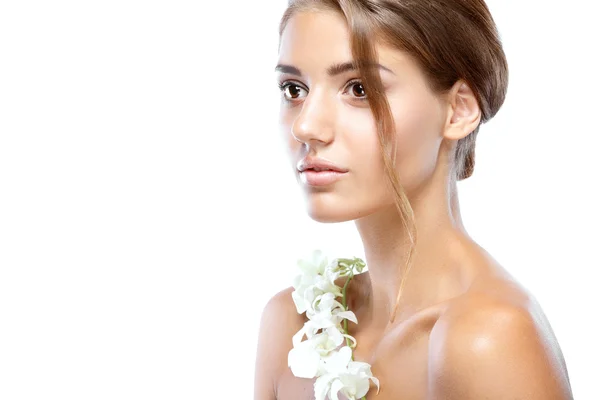 Jovem mulher com rosto claro natural compõem seu cabelo com uma flor branca em um fundo claro — Fotografia de Stock