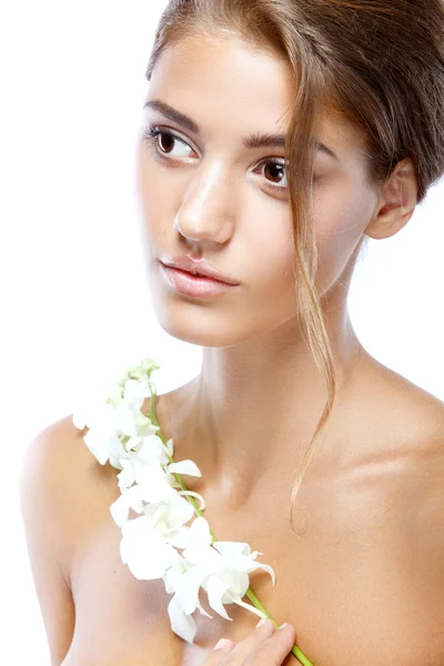 Jonge vrouw met duidelijk gezicht natuurlijke haar make-up omhoog met een witte bloem op een lichte achtergrond — Stockfoto