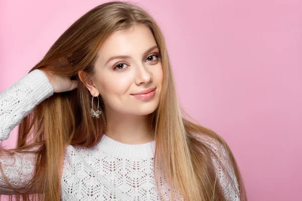 Mujer joven bonita sonriendo sobre un fondo rosa. — Foto de Stock