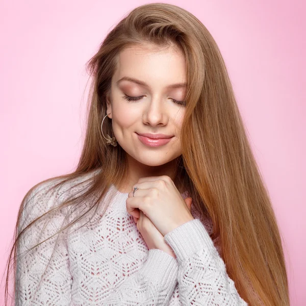 Mujer joven y bonita con los ojos cerrados sonriendo al fondo rosa . — Foto de Stock