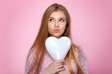 Heartshaped balon tutan tatlı sarışın kadın. Stüdyo portre pembe bir arka plan üzerinde. Doğum günün kutlu olsun. Sevgililer günü. Neşeli
