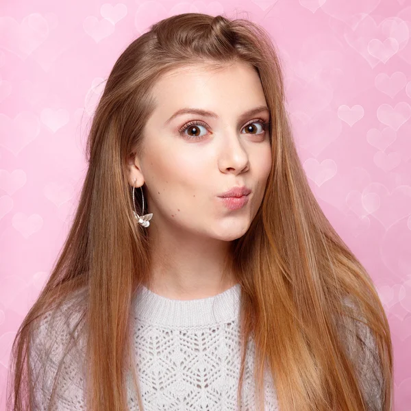 Dulce mujer rubia sonriendo, guiñando un ojo. Día de San Valentín. fondo bokeh en forma de corazón alegre —  Fotos de Stock