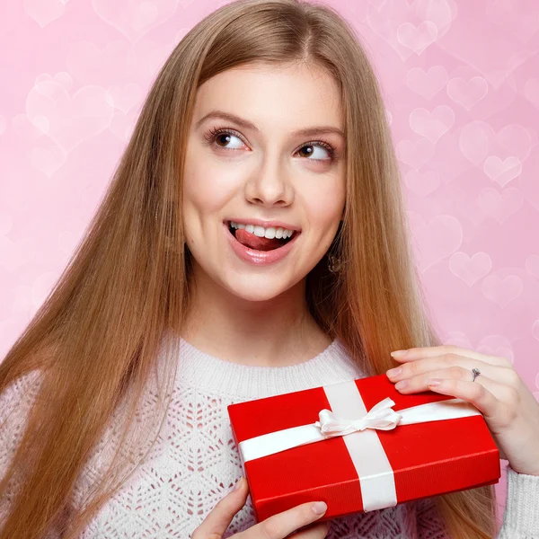 Valentines Day. Sweet blonde woman holding a gift box. heartshaped bokeh background Joyful — Stock Photo, Image