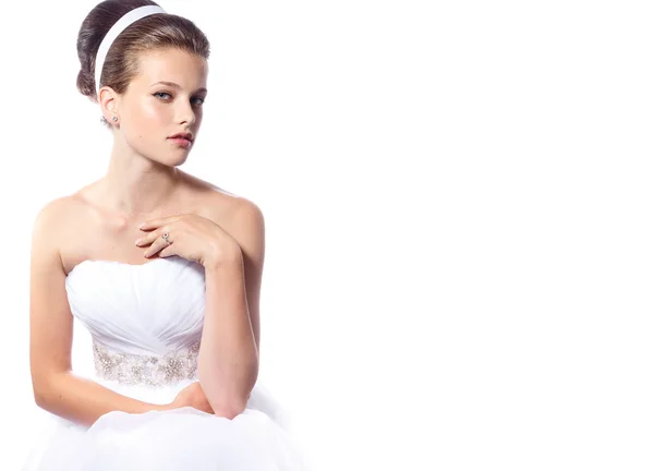 Beautiful young bride in a wedding dress with her cute hairstyle on the white isolated background — Stock Photo, Image