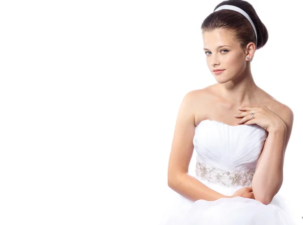 Mooie jonge bruid in een trouwjurk met haar schattige kapsel op de witte geïsoleerde achtergrond — Stockfoto