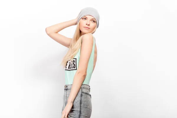 Ung blond modell poserar på en vit bakgrund. Fasion shootina på studio. — Stockfoto