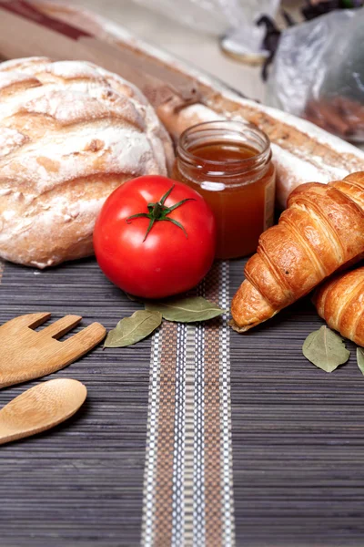 Pane fresco fatto in casa e miele, verdure su un vecchio tavolo di legno. Stile rustico . — Foto Stock