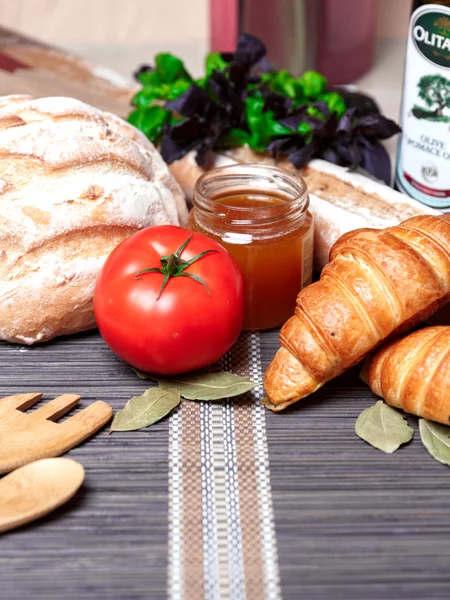 Fresh homemade bread and honey, vegetables on an old wooden table. Rustic style. — Stock Photo, Image