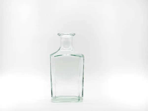 白い背景に1本の空のガラスボトル 透明な四角いボトル 垂直滞在無色の瓶の正面図 — ストック写真