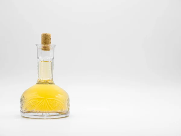 白を基調としたコルクキャップで閉じられたアルコール飲料付きのガラスカフェ 黄色の液体と透明なボトル 垂直滞在瓶の正面図 — ストック写真