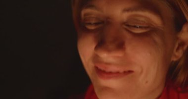 Kırmızı bir bluz giymiş, mum içinde gülümseyen bir kadın ortam aydınlatıyordu..